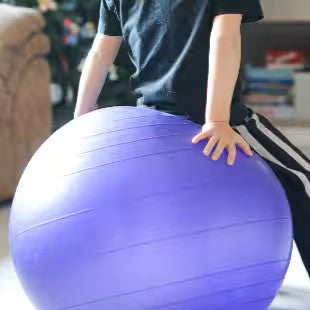 Boy sitting on exercise ball