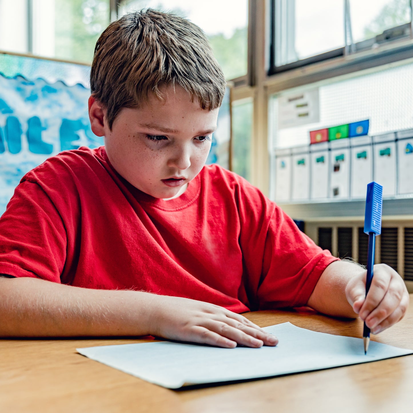 Boy using ARK Brick Stick Pencil Toppers