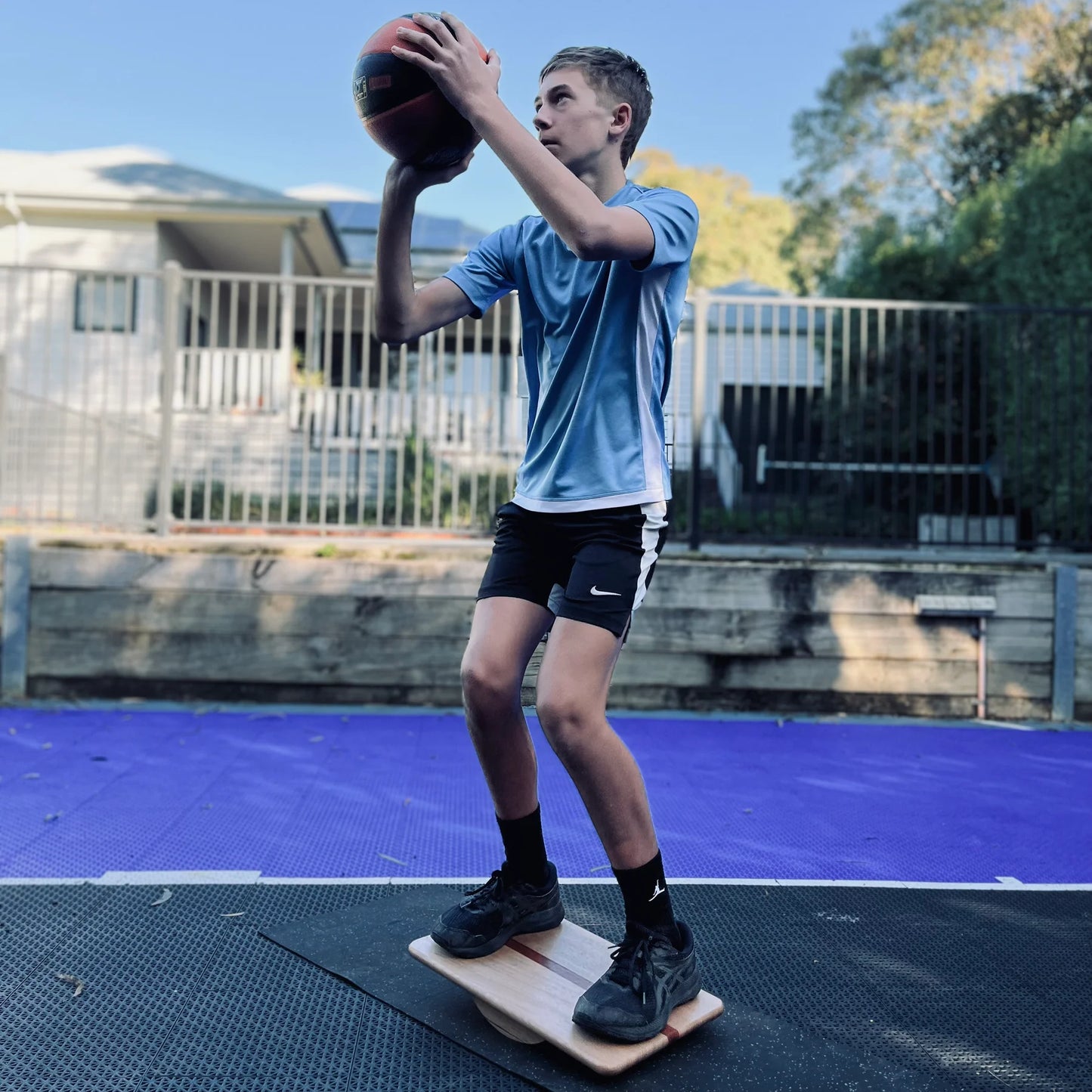 Boy shooting hoops on Regular wobble board