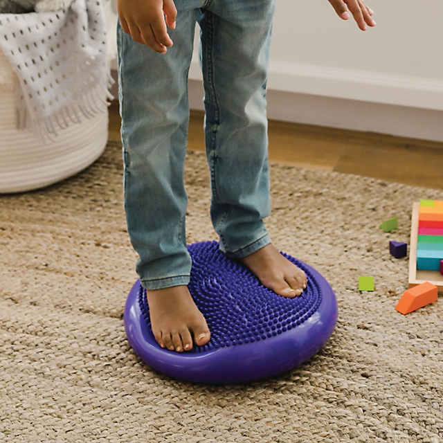 Boy standing on Sensory Genius Wobble Cushion