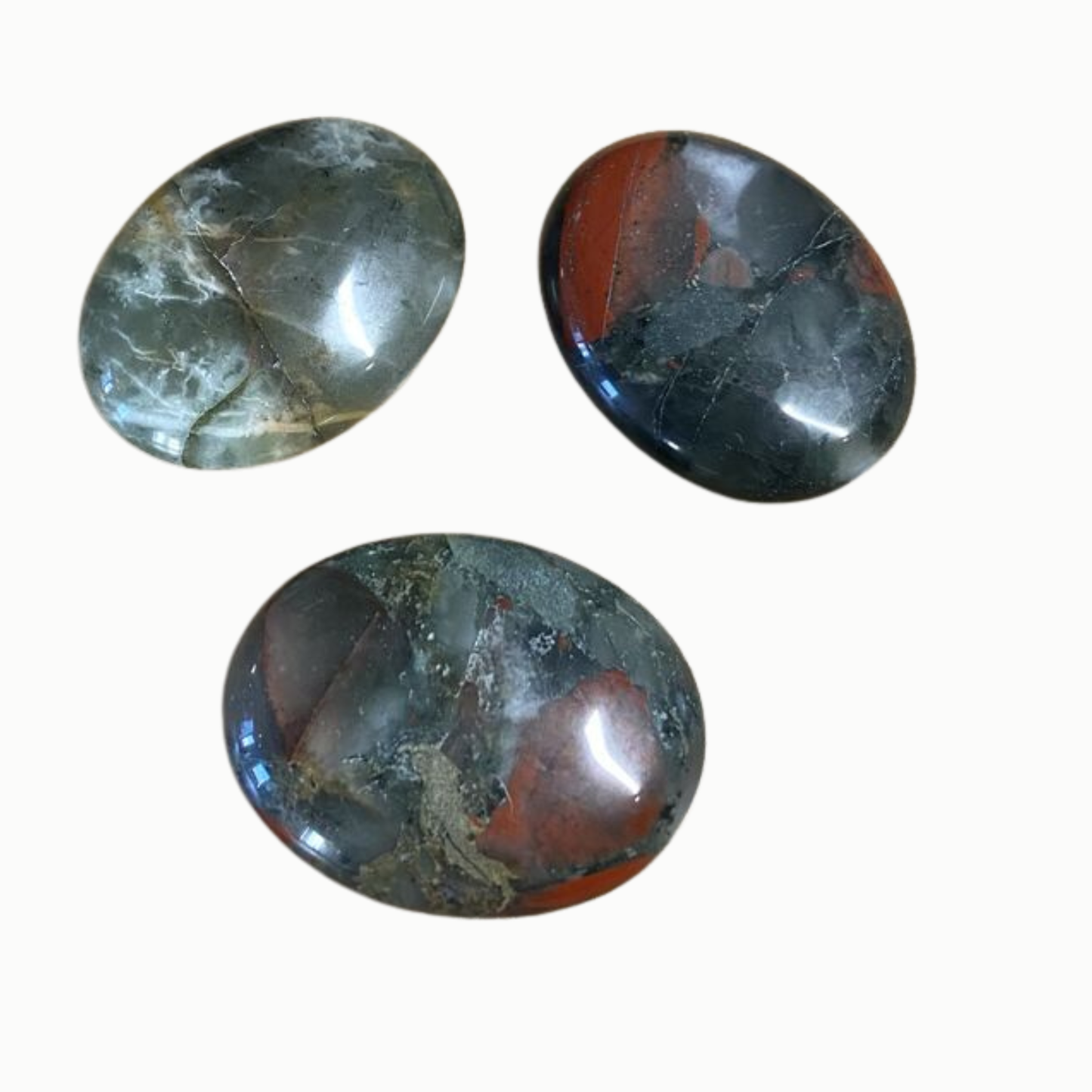 Three oval-shaped gemstones with marbled patterns on a white background