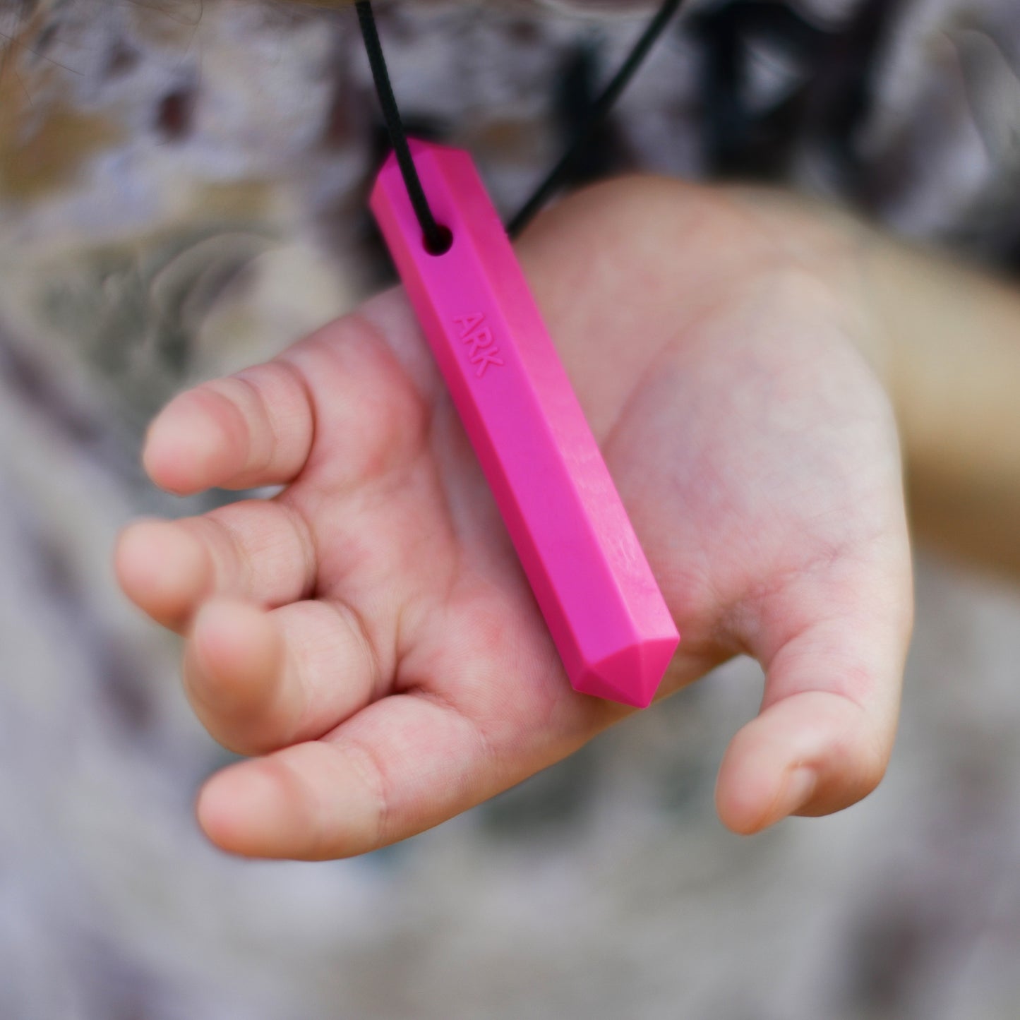 Ark Krypto-bite Gem Necklace Chew Hand holding pink one
