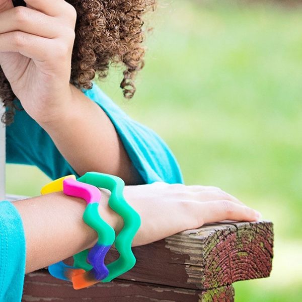Girl wearing Chewigem wave bangle sensory chew