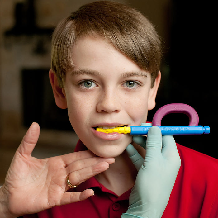 Boy using ARK Z-Grabber vibrating oral motor tool