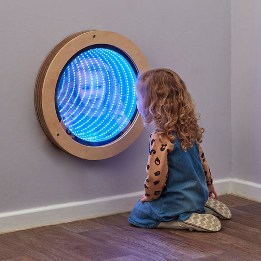Girl looking in sensory infinity mirror