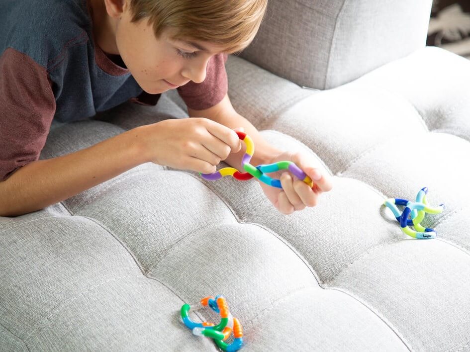 Boy playing with Tangle Jnr