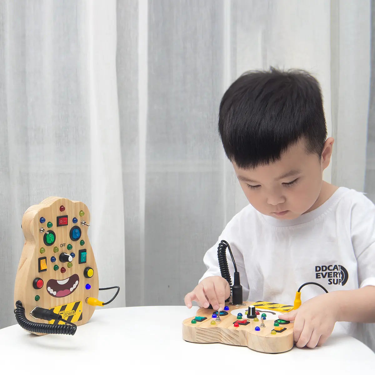 Boy playing with Sensory Street Wooden Light up LED Busy Board 