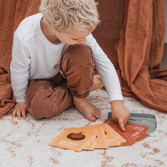 Boy looking at Creative Sprout Emotions Cards for kids
