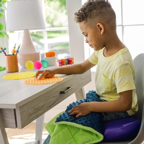 Boy sitting on Sensory Genius Wobble Cushion