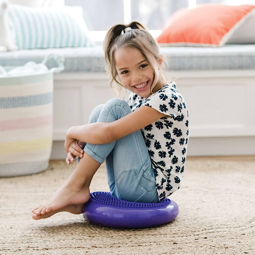 Girl sitting on Sensory Genius Wobble Cushion