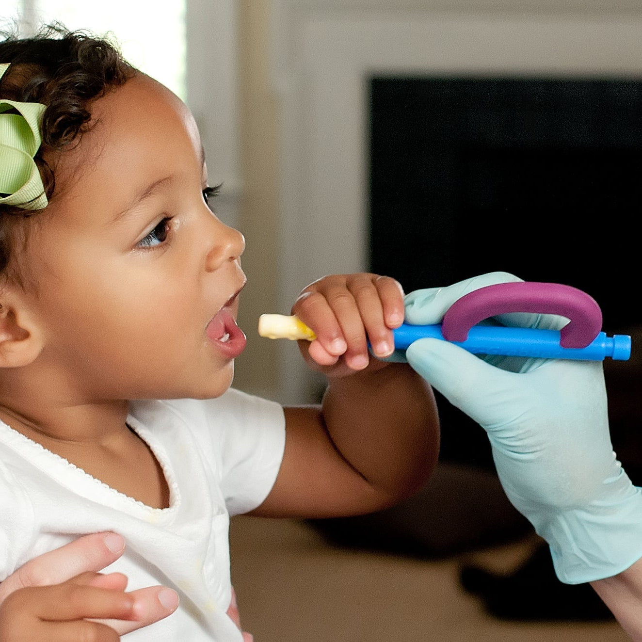 Girl using ARK Z-Grabber vibrating oral motor tool