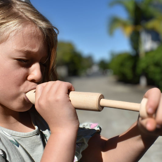 Child using Wooden Slide whistle