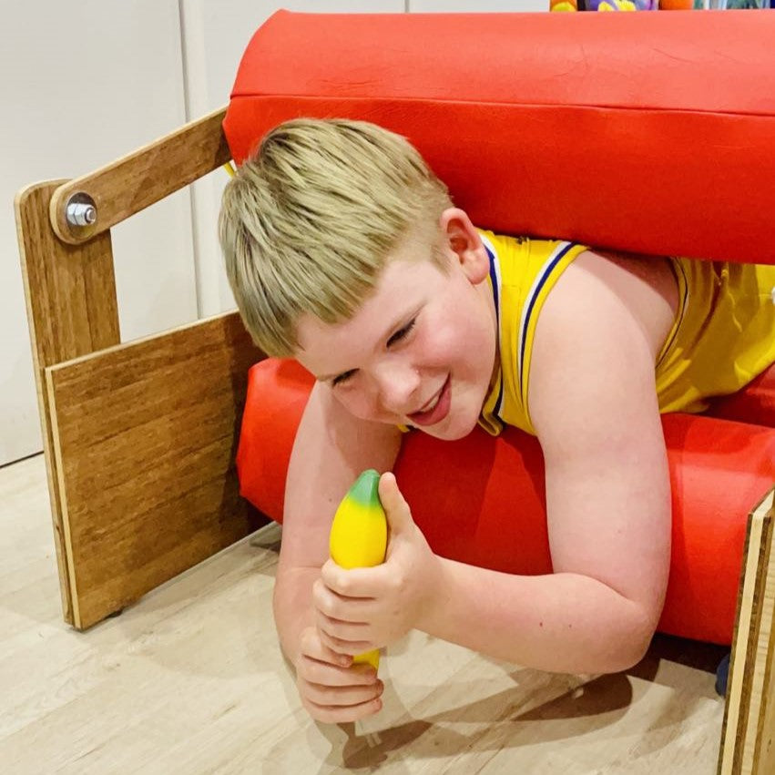 Boy going through sensory pressure roller with fidget