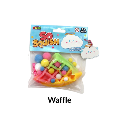 TABA So Squish Rainbow Waffle Squishy with Pink icing and pink, yellow, blue and white pom poms.