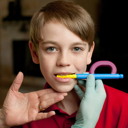 Boy using ARK Z-Grabber vibrating oral motor tool