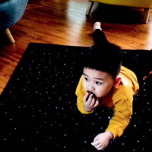 Boy lying on LED light sensory rug carpet