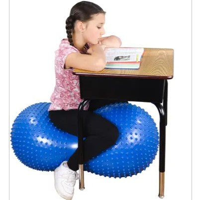 girl sitting on inflatable sensory ball with tactile nubs
